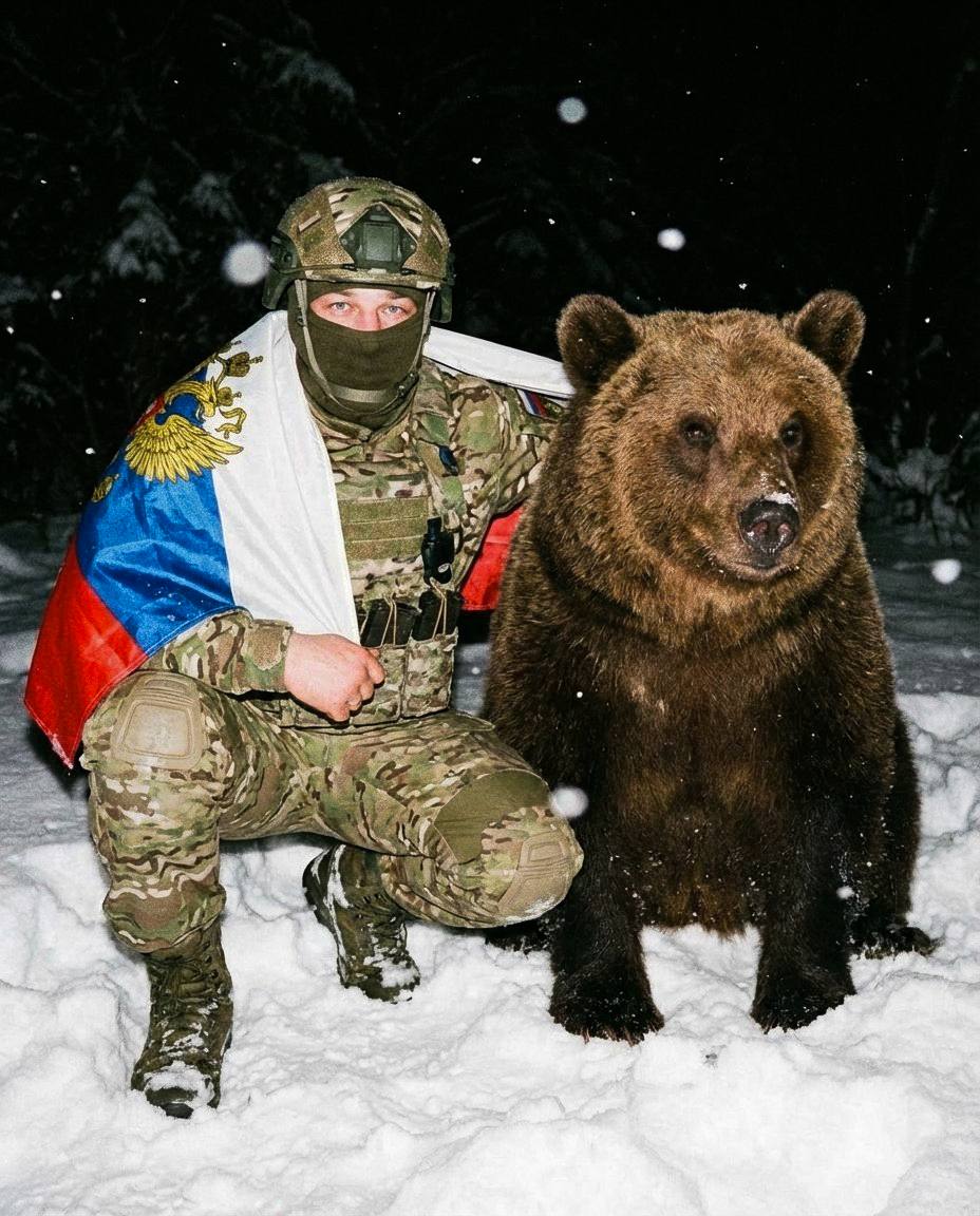 Мужчина сидит на снегу на корточках На нём...