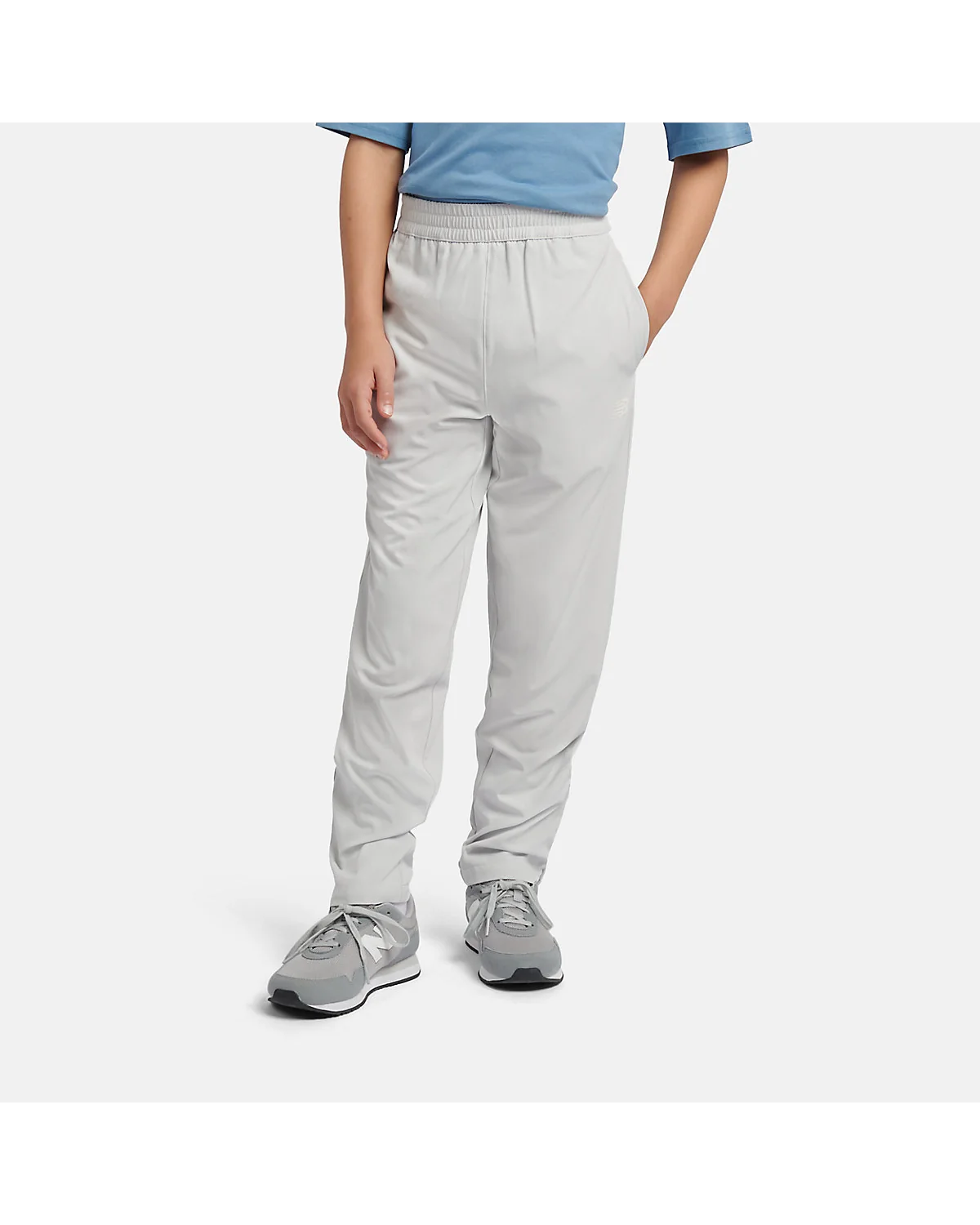 Серые спортивные брюки New Balance NB Essential Track Pant на мальчике.