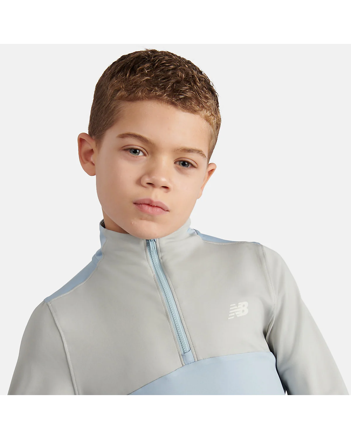 Пуловер New Balance серый, крупный план молнии и логотипа.
