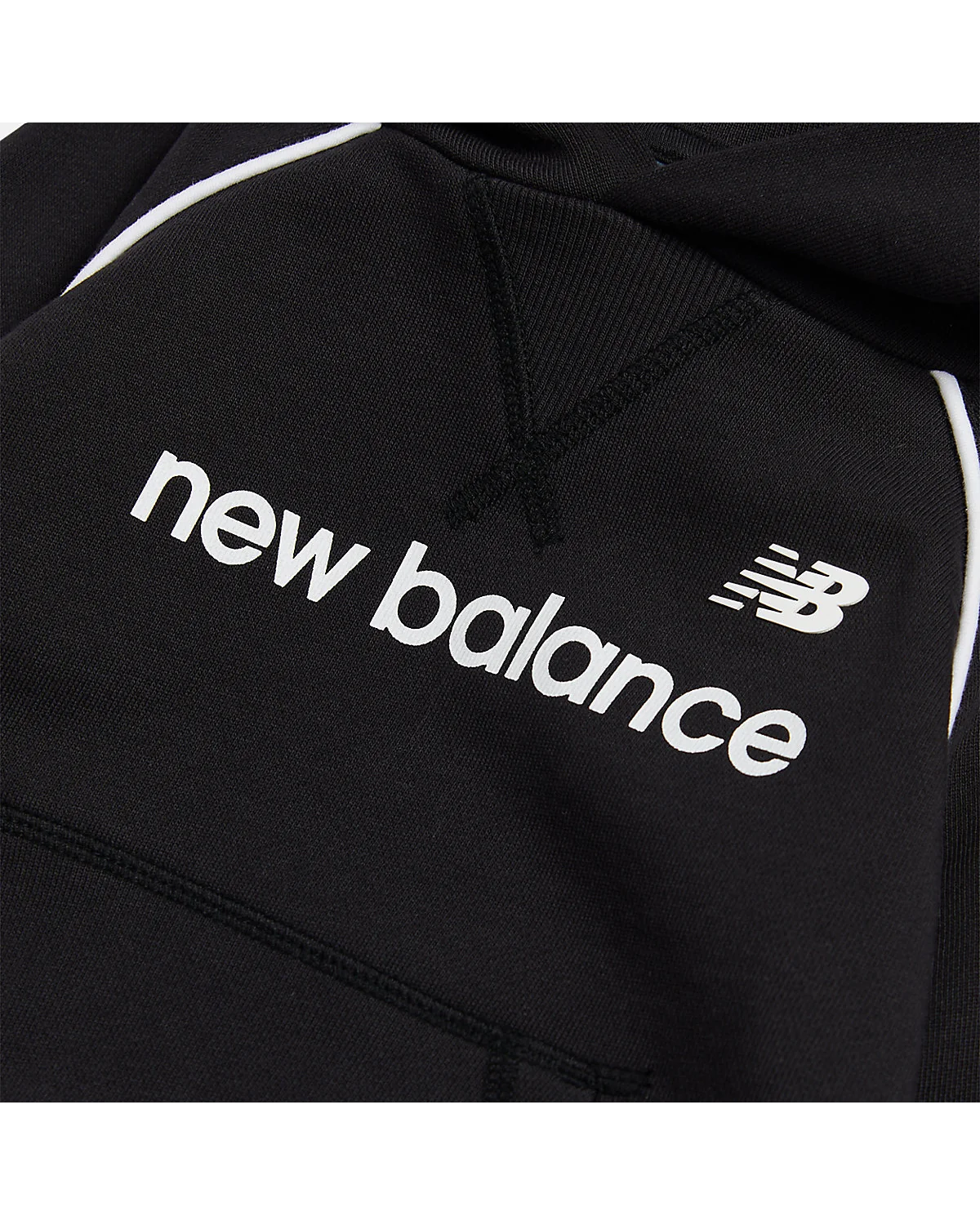 Крупный план рефлексивной полосы и логотипа New Balance на чёрном худи