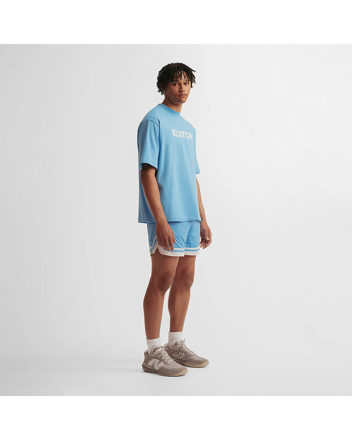 Мужчина в голубых спортивных шортах New Balance, вид спереди