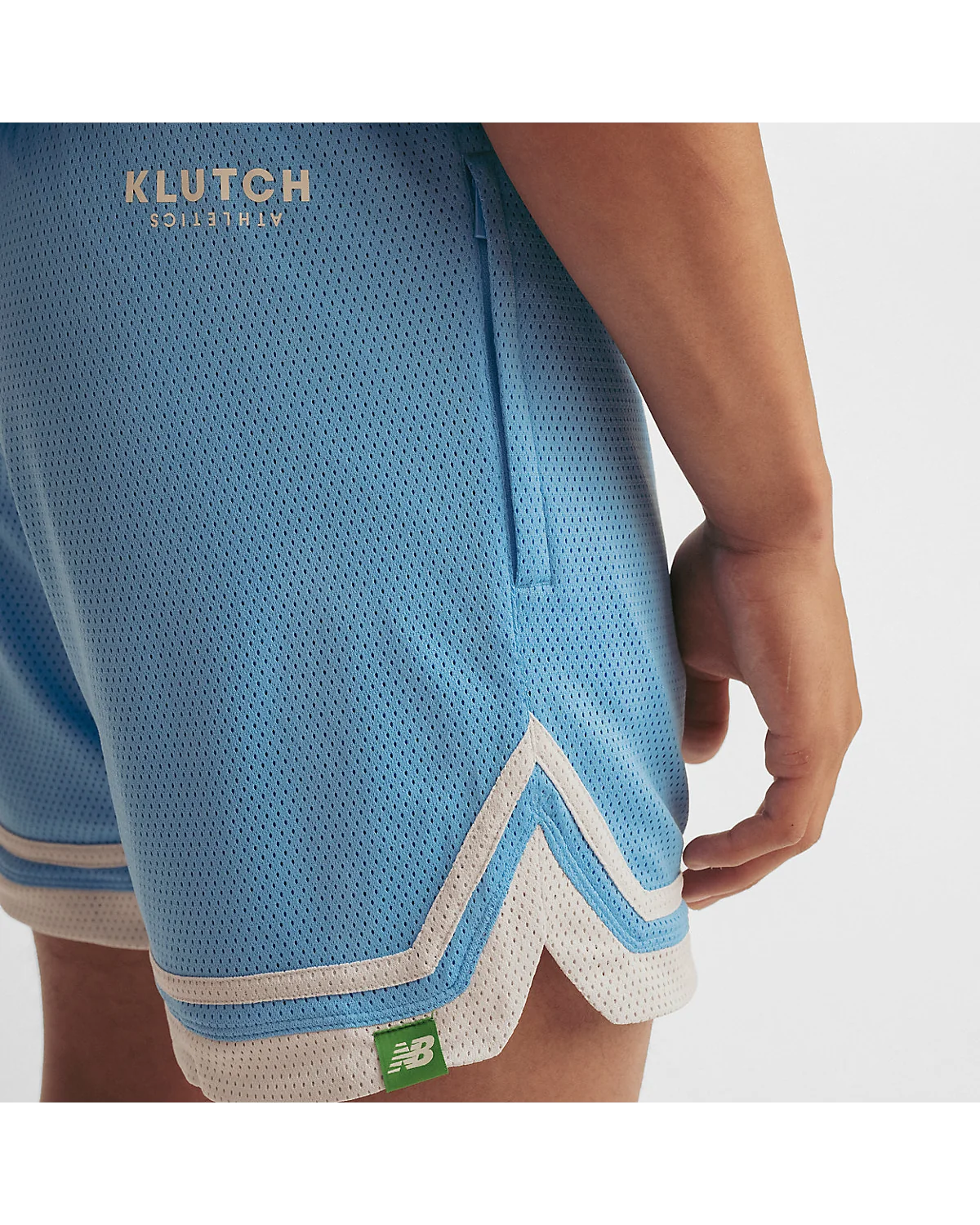 Деталь текстуры и контрастной отделки голубых спортивных шорт New Balance