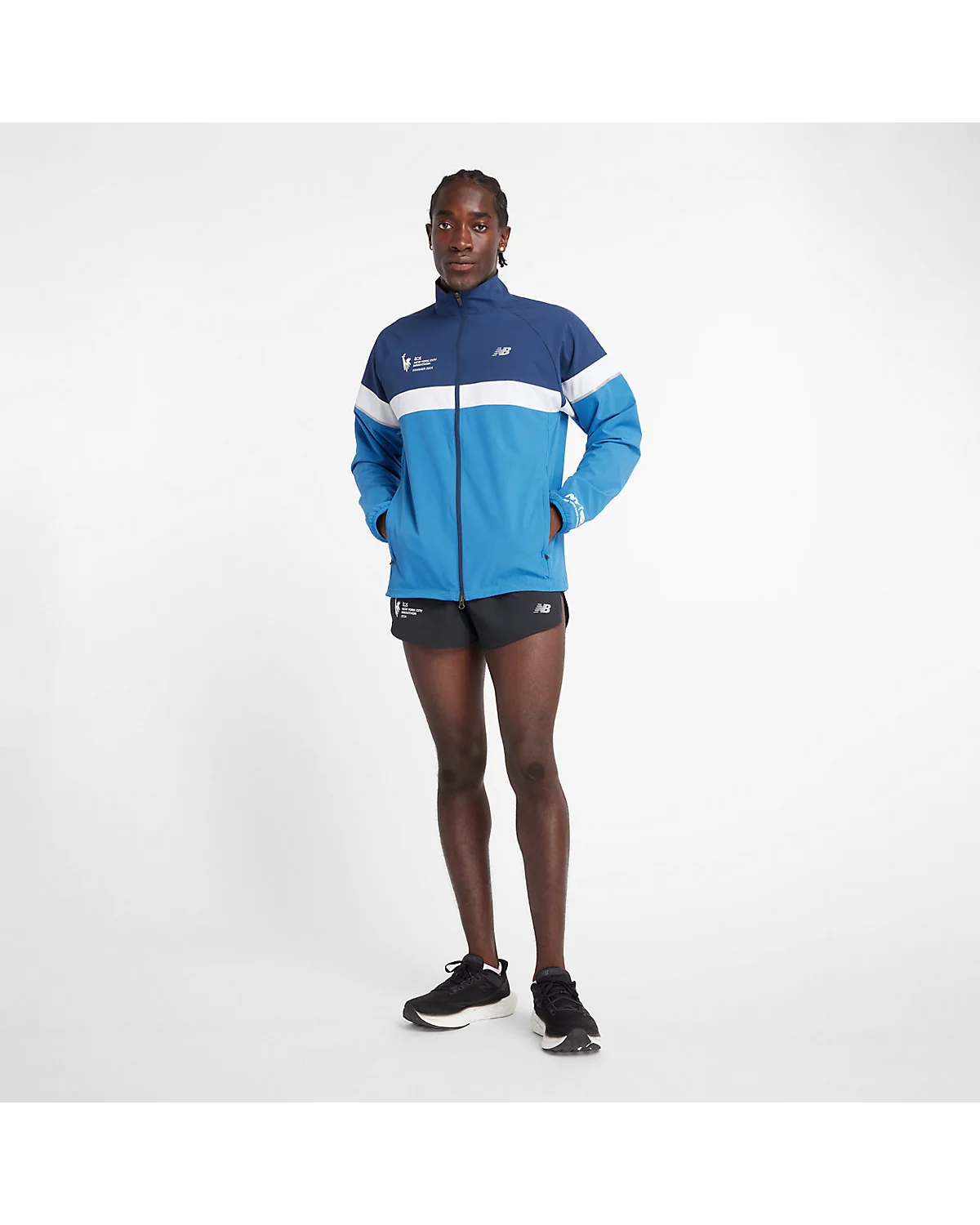 Мужчина в синей беговой куртке New Balance, вид сбоку показывает силуэт