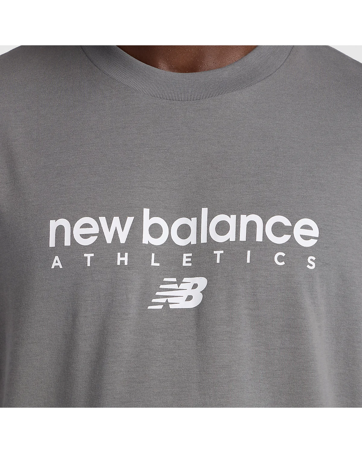 Крупный план белого логотипа на груди серой футболки New Balance