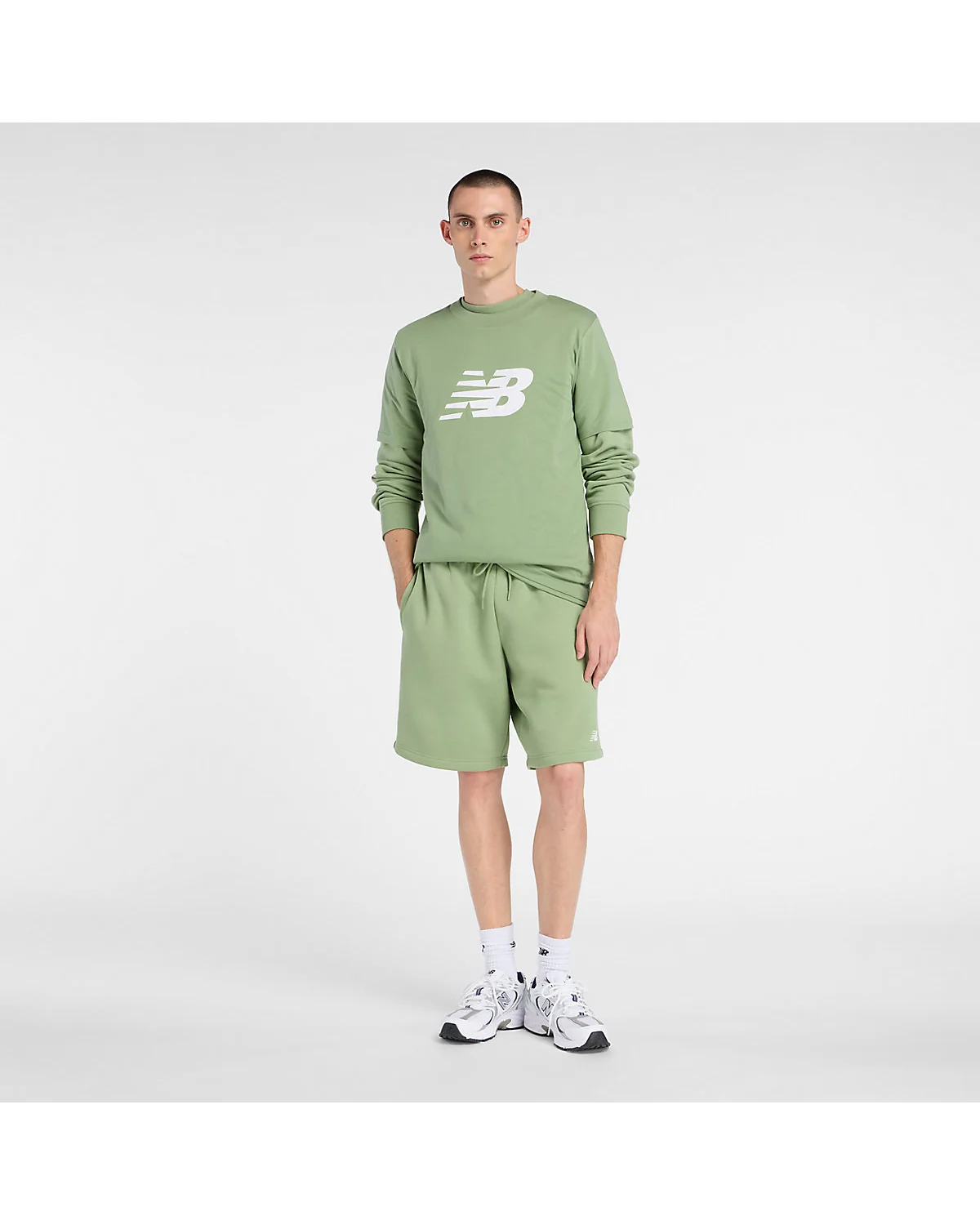 Зелёная футболка New Balance на фигуре, демонстрирует длину и посадку, вид в полный рост.