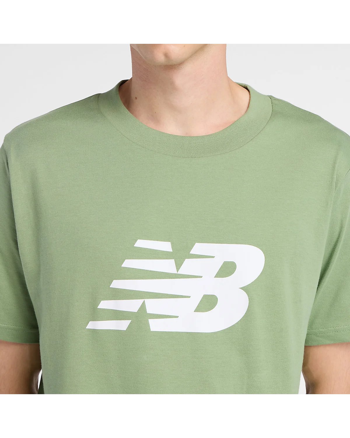 Крупный план белого логотипа New Balance на груди зелёной футболки.