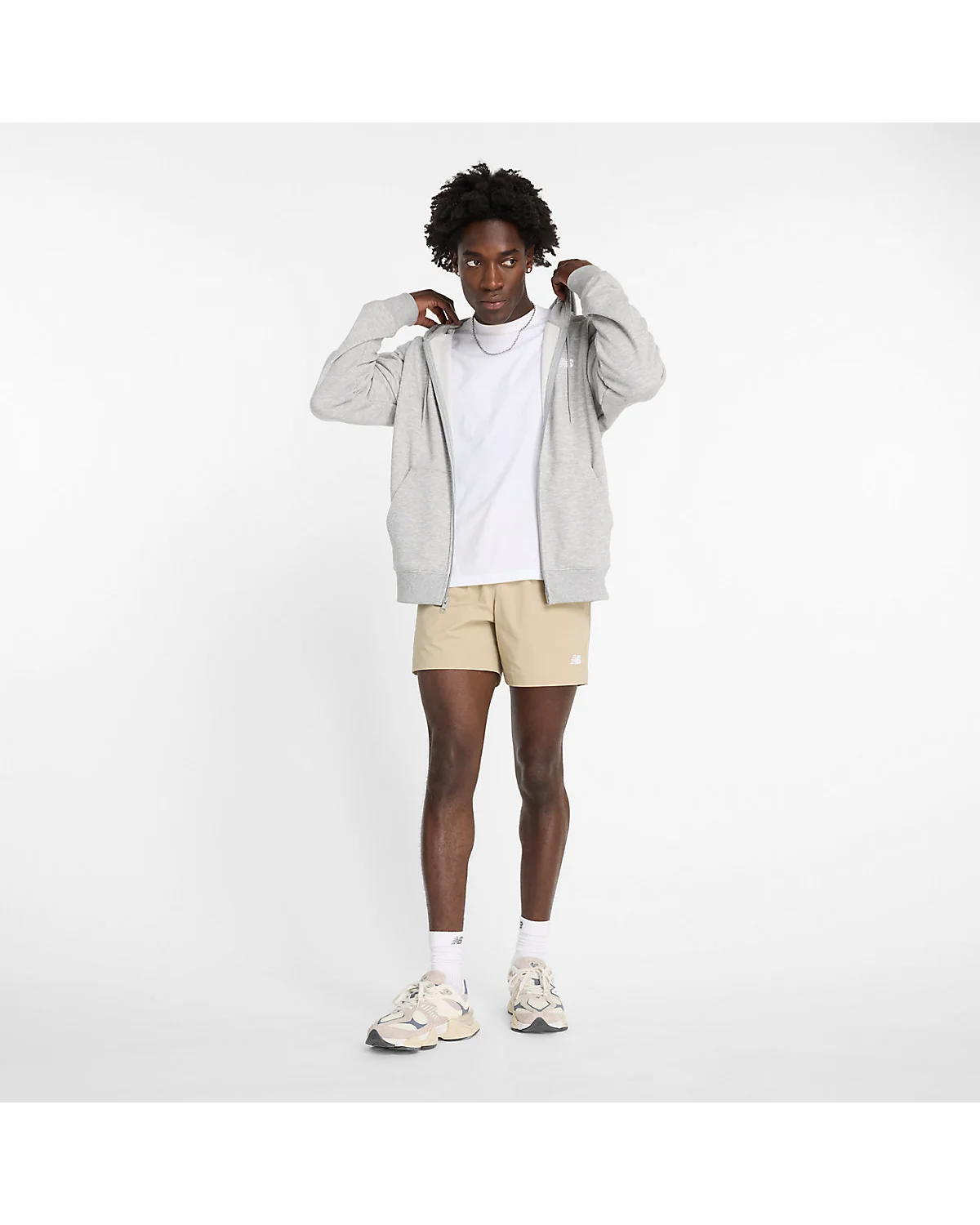 Крупный план ткани и пояса серо-бежевых шортов New Balance.