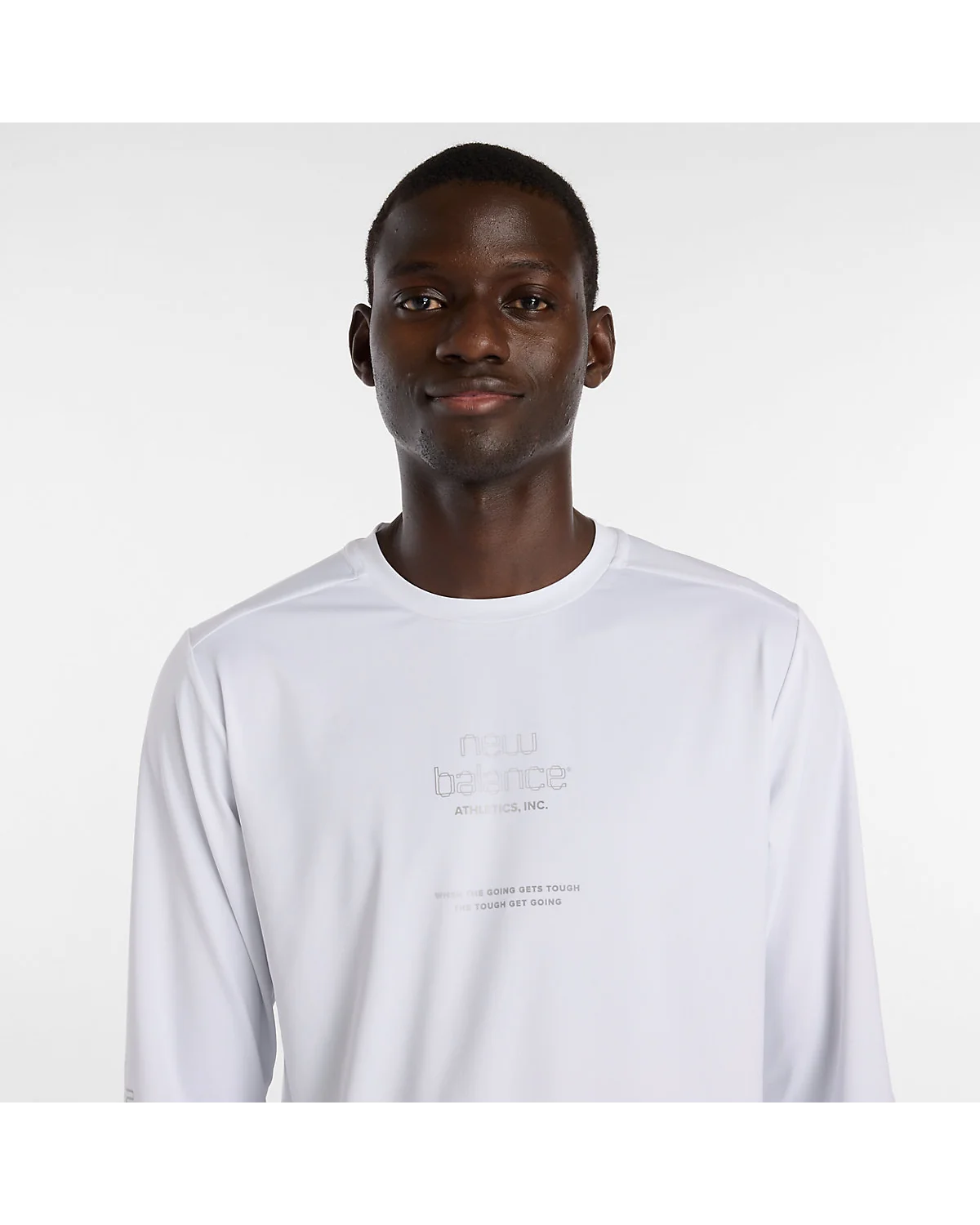 Крупный план светоотражающей графики на груди белого лонгслива New Balance