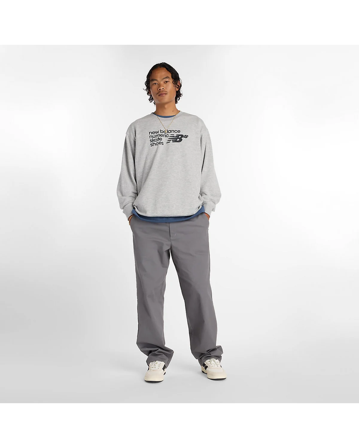 Серые брюки New Balance в полный рост, боковой вид.