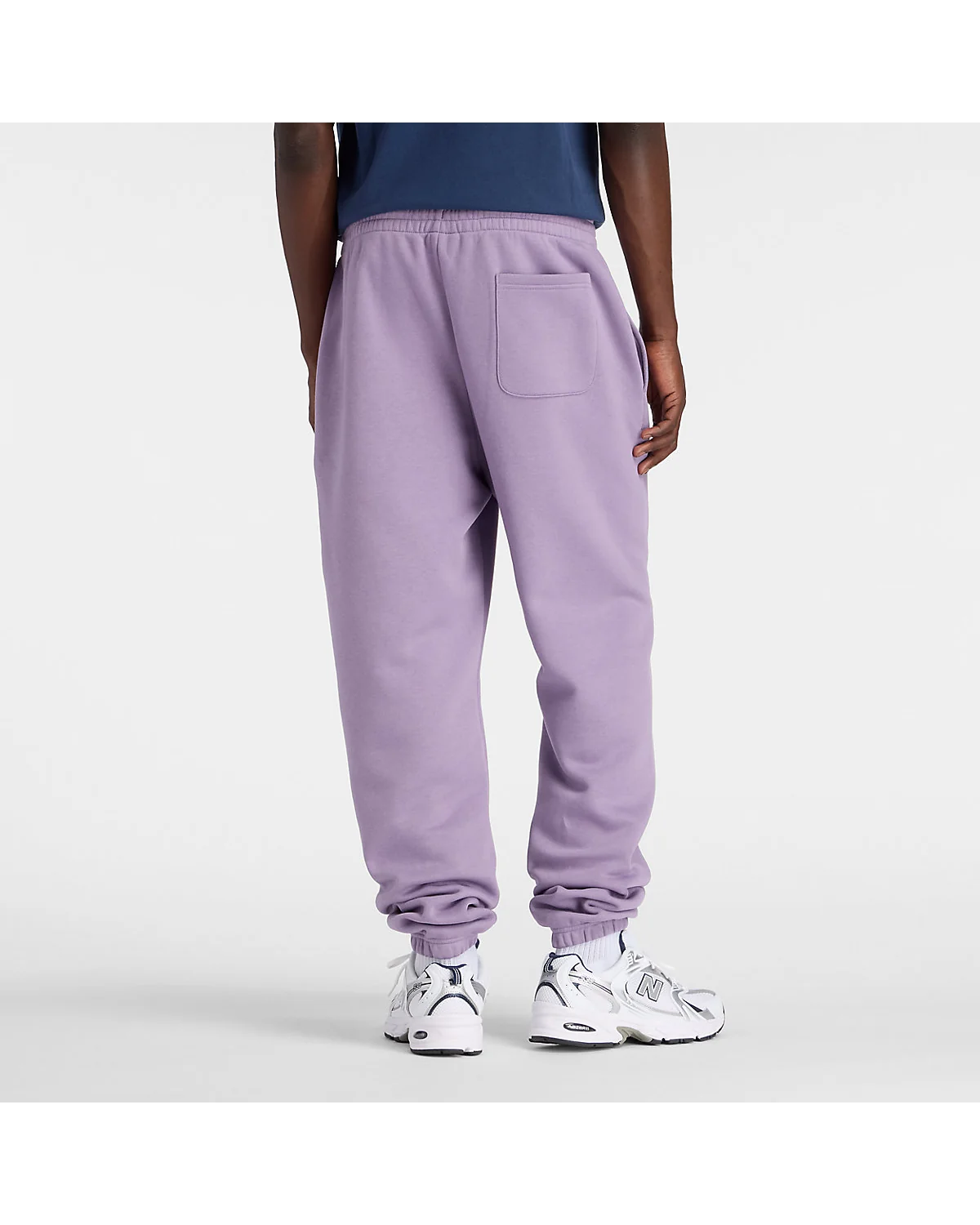 Фиалковые флисовые джоггеры New Balance на модели, вид сзади