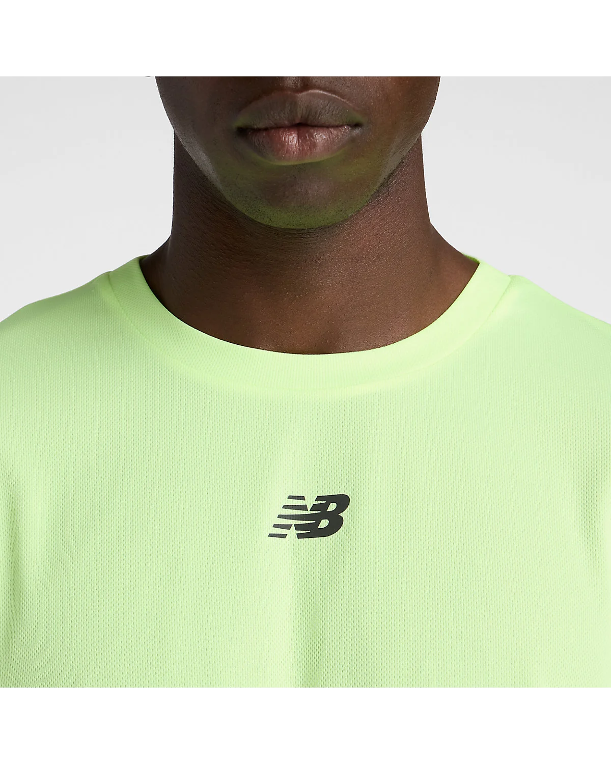 Крупный план логотипа и текстуры ткани беговой футболки New Balance, вид на грудь
