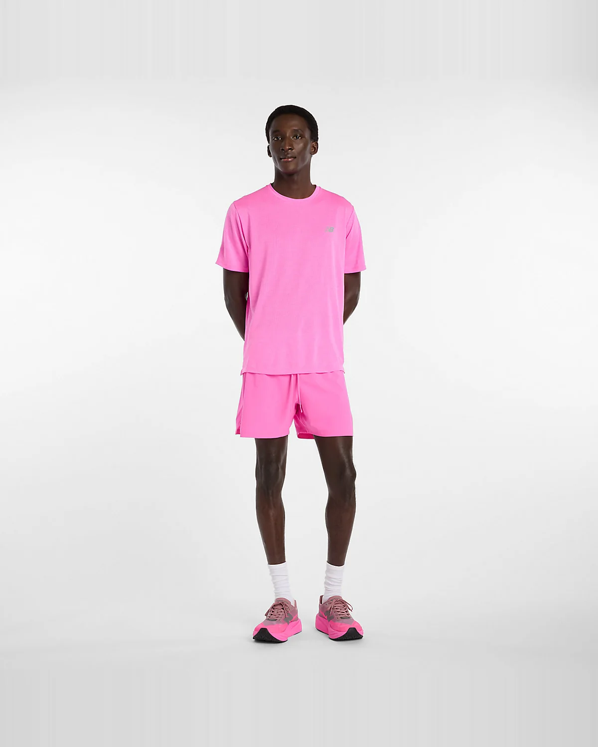 Розовые беговые шорты New Balance на модели в полный рост, вид спереди