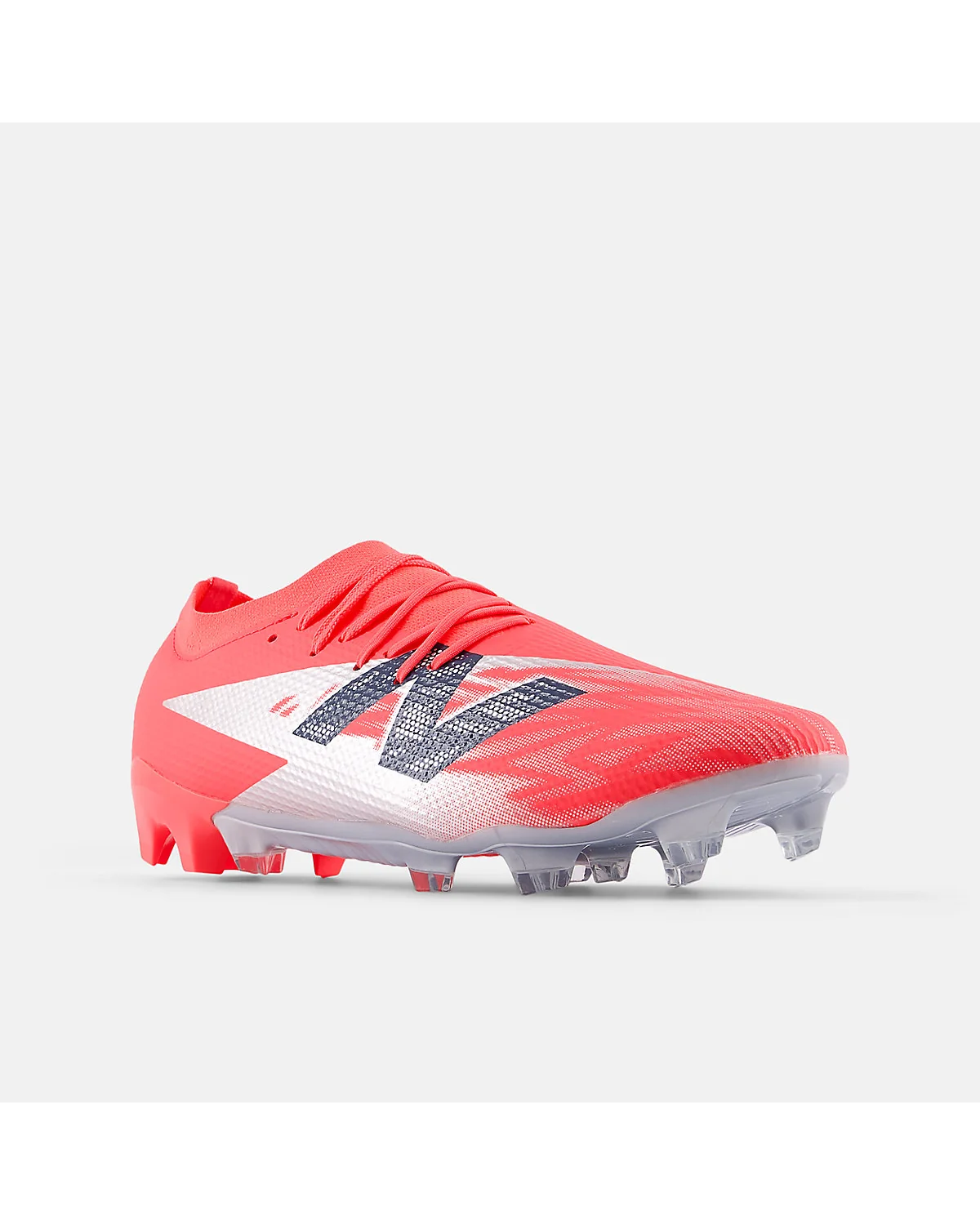 Красные бутсы New Balance Furon Team FG V8, видны металлические шипы.