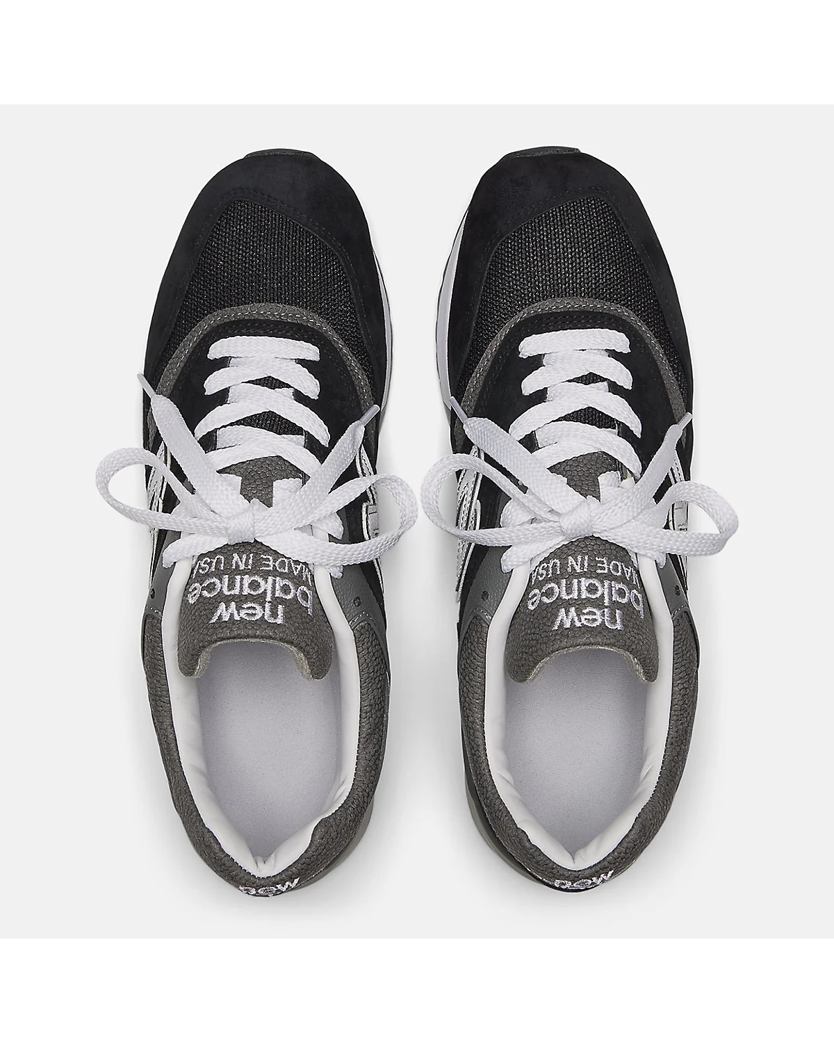 Крупный план воротника и сеточной вставки чёрных кроссовок New Balance 997.