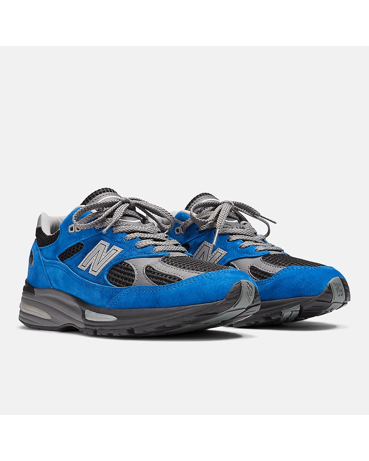 Две синие кроссовки New Balance 991v2 рядом, вид спереди.