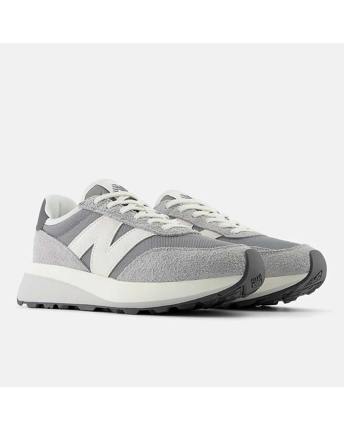Серые кроссовки New Balance 370, полуоборот, видны передние и боковые панели.