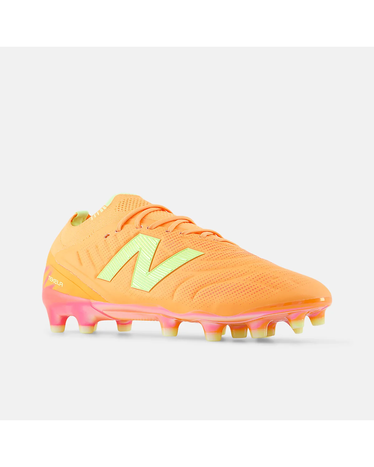 Оранжевые бутсы New Balance Tekela Elite, вид с другого угла, розово-жёлтая подошва.