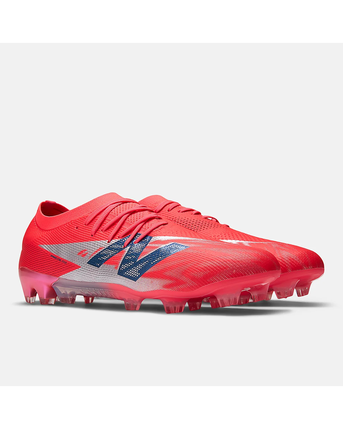 Красные бутсы New Balance Furon Elite, трёхчетвёртный вид с шипами.
