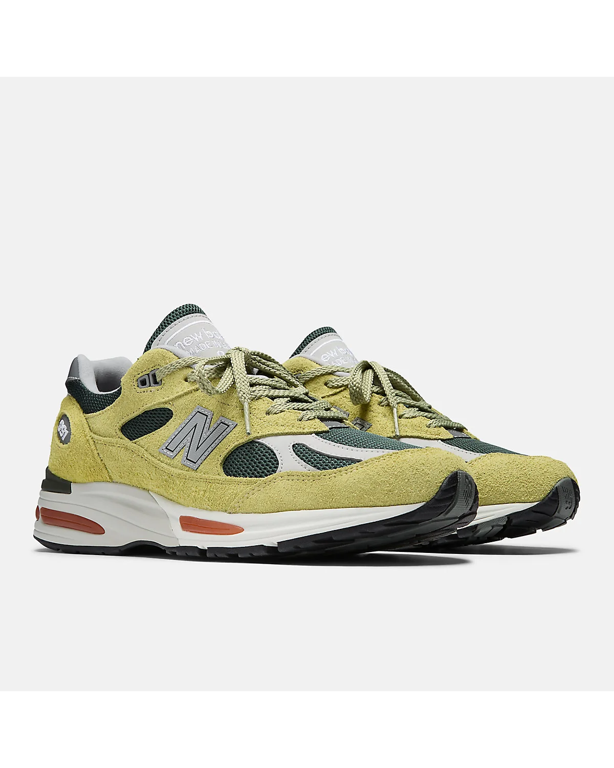 Бежево-зелёные кроссовки New Balance 991v2 с трекинг-зелёными панелями, разносторонний вид.