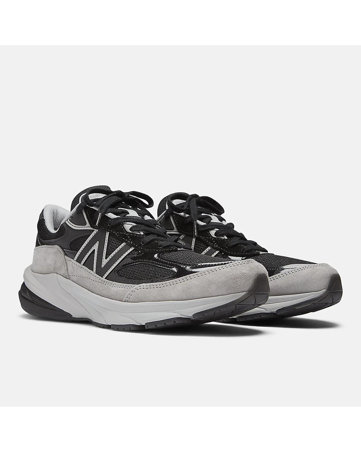 Пара чёрных кроссовок New Balance 990v6 под углом, вид спереди.