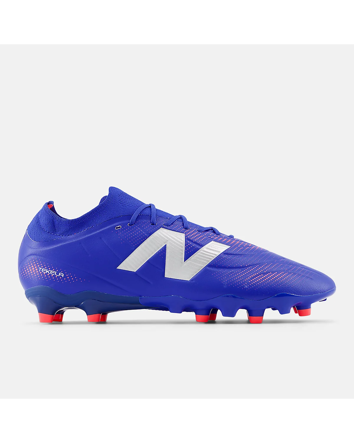 Синие футбольные бутсы New Balance Tekela Team с красными шпильками, вид сбоку.