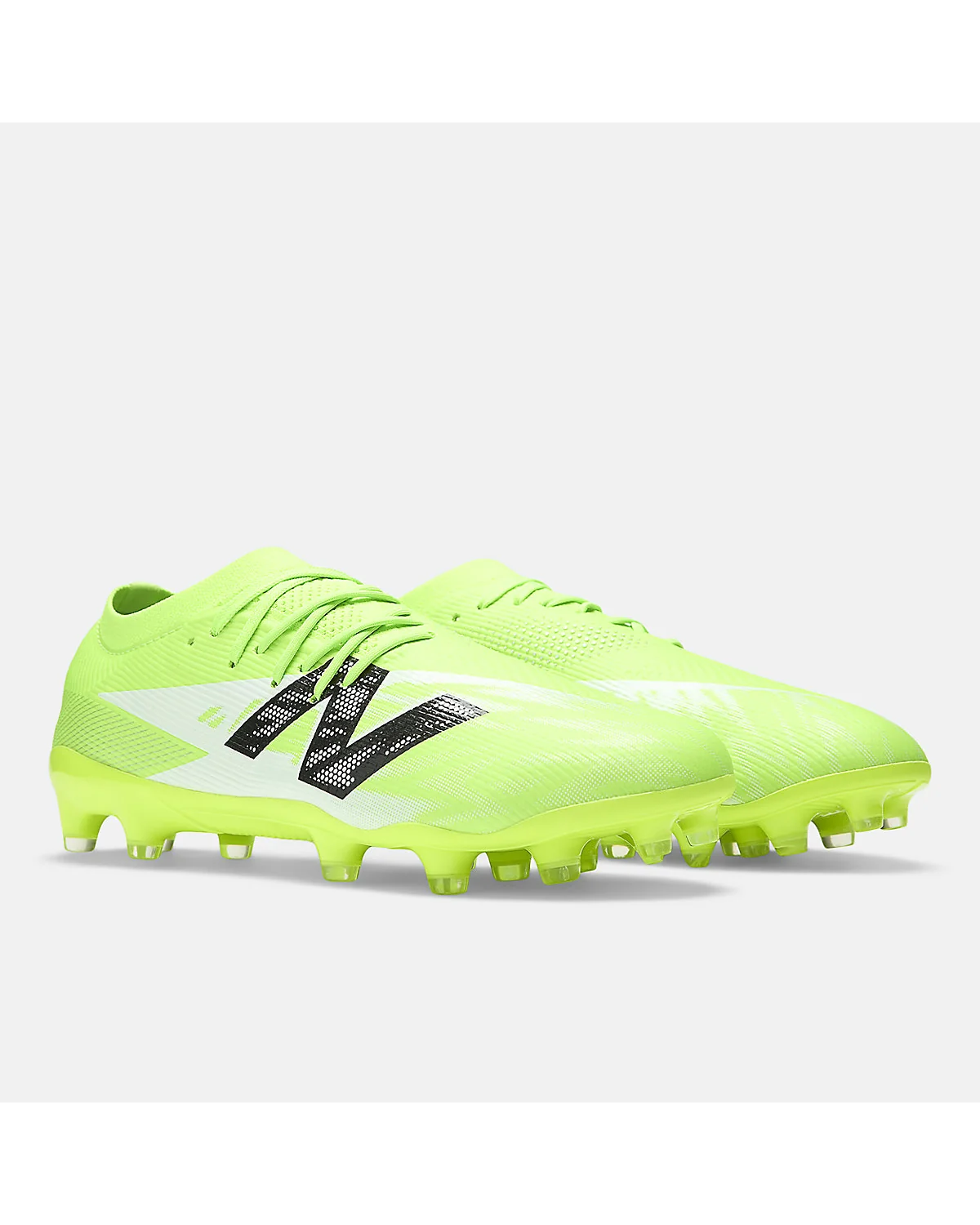 Подошва неоново-зелёных футбольных бутс New Balance Furon, пластиковые шипы