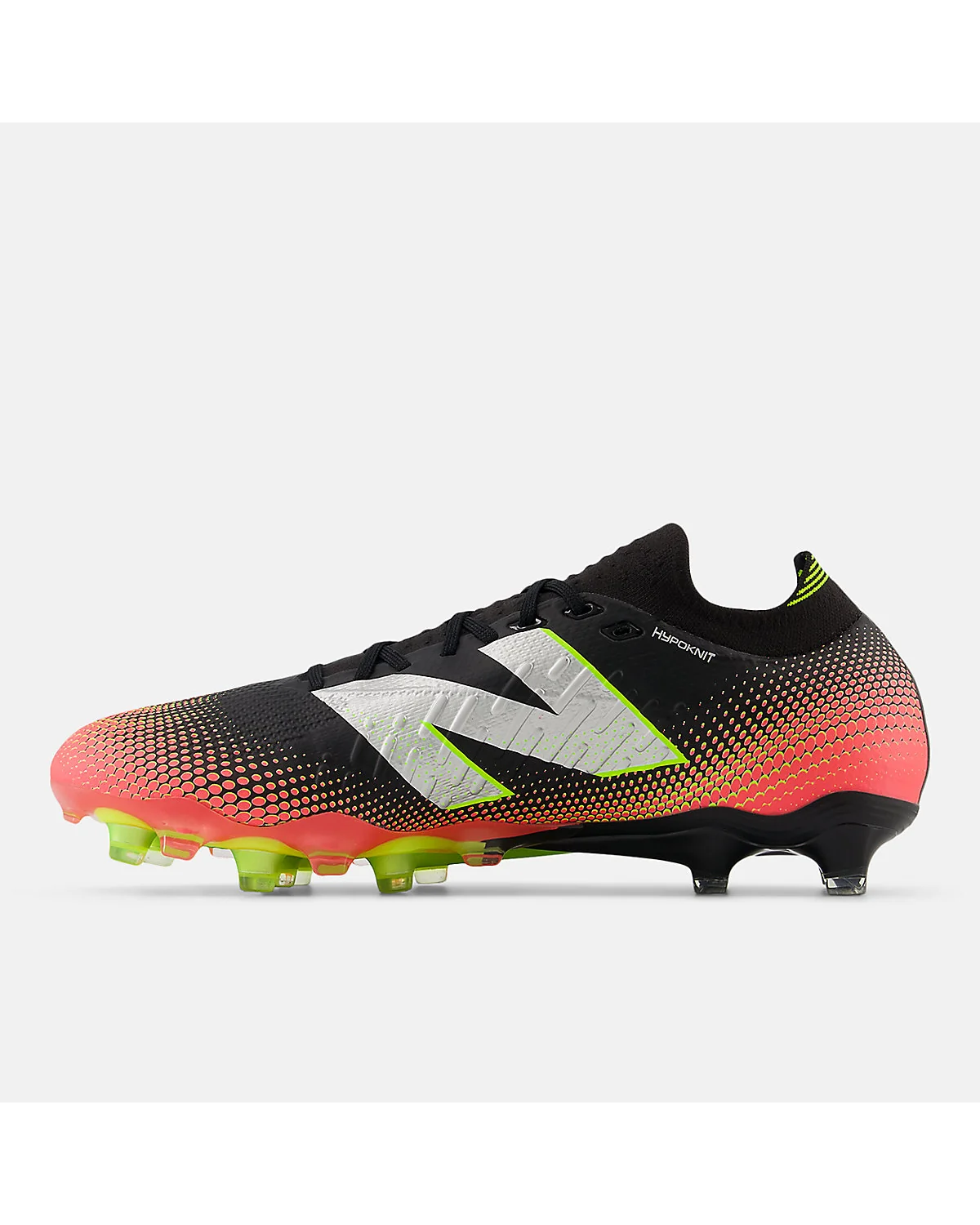 Боковой ракурс чёрных футбольных бутс New Balance TEKELA PRO с коралловым передком.