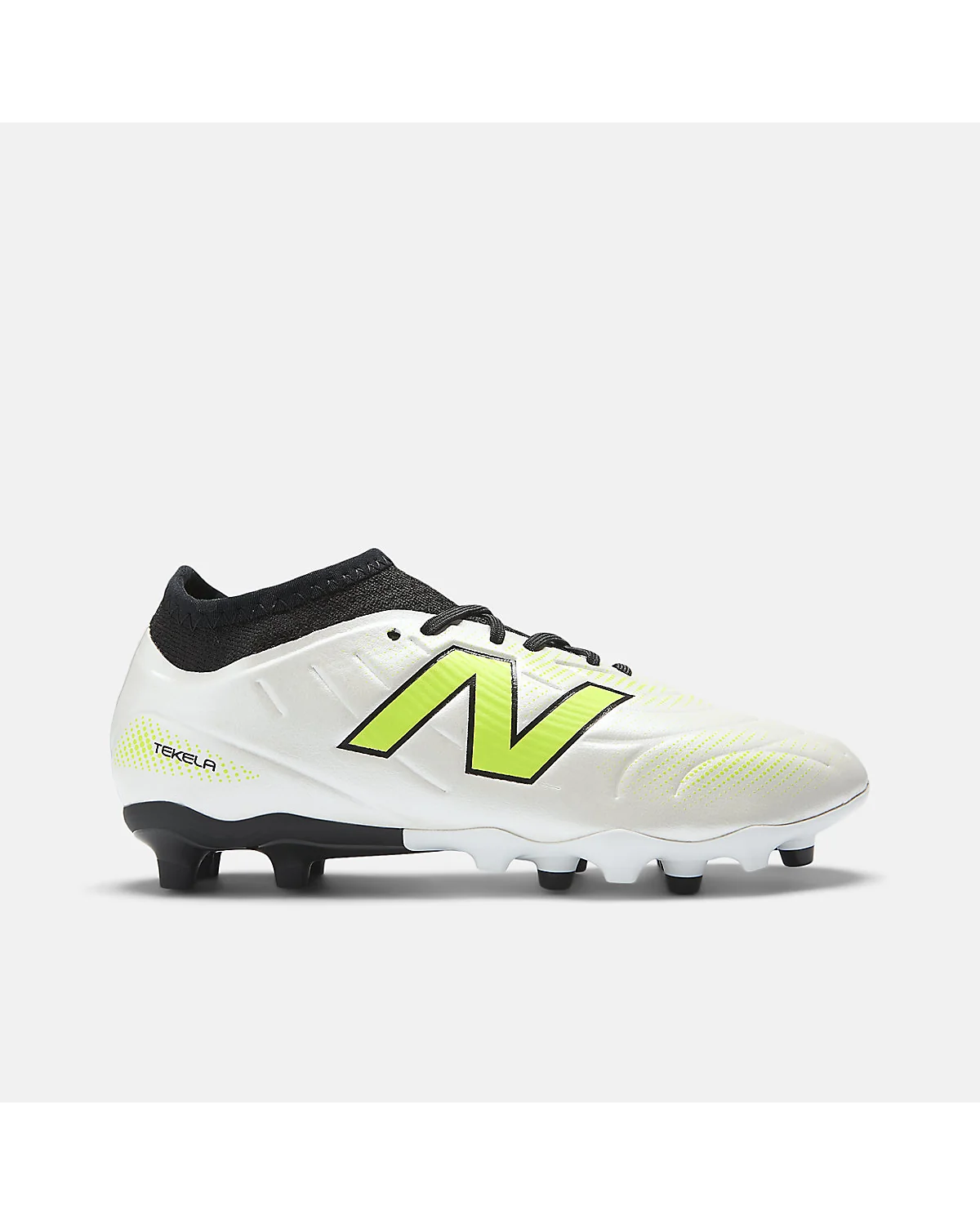 Бело-зелёные футбольные бутсы New Balance, видна подошва с шипами