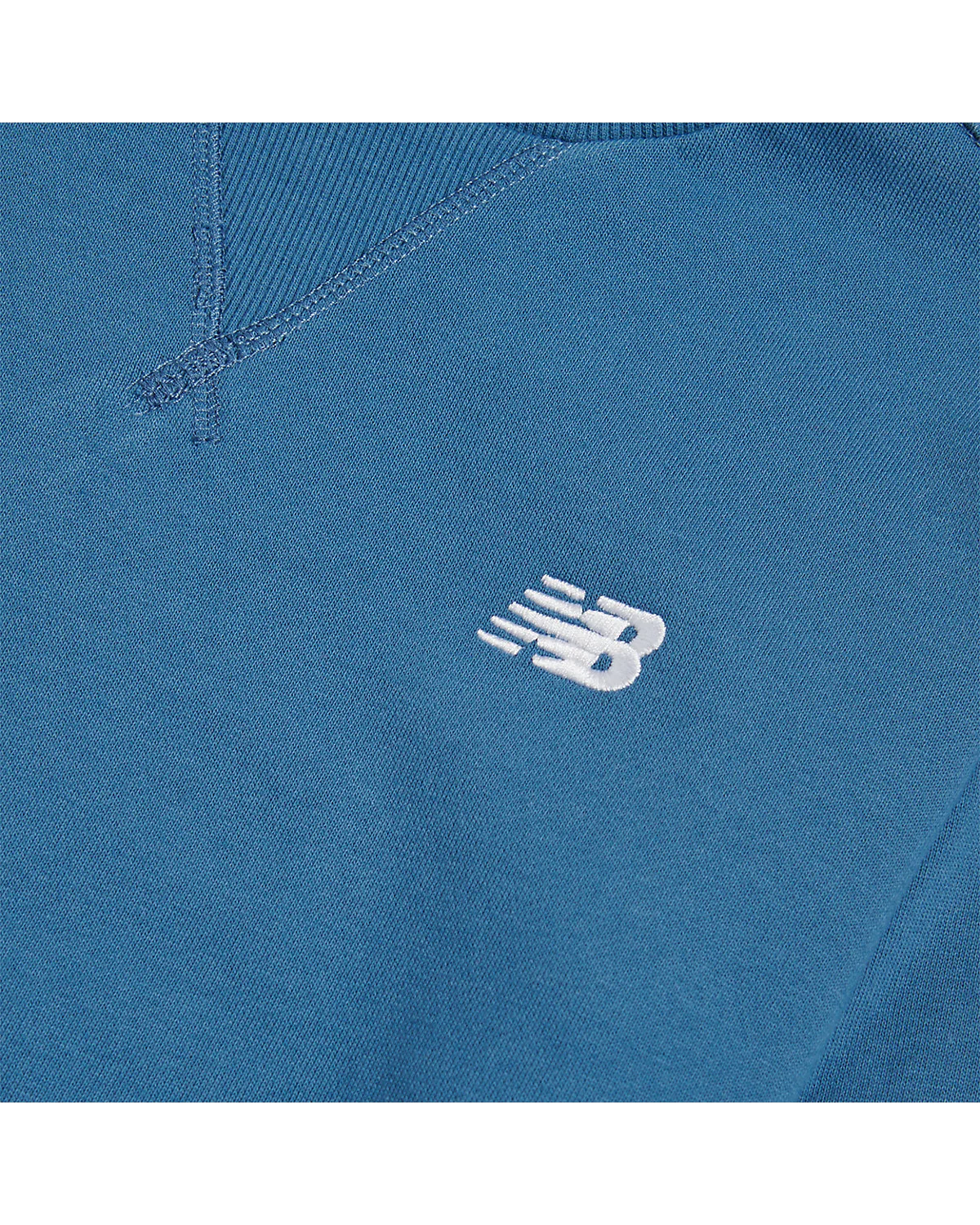 Вышитый логотип New Balance на груди толстовки.