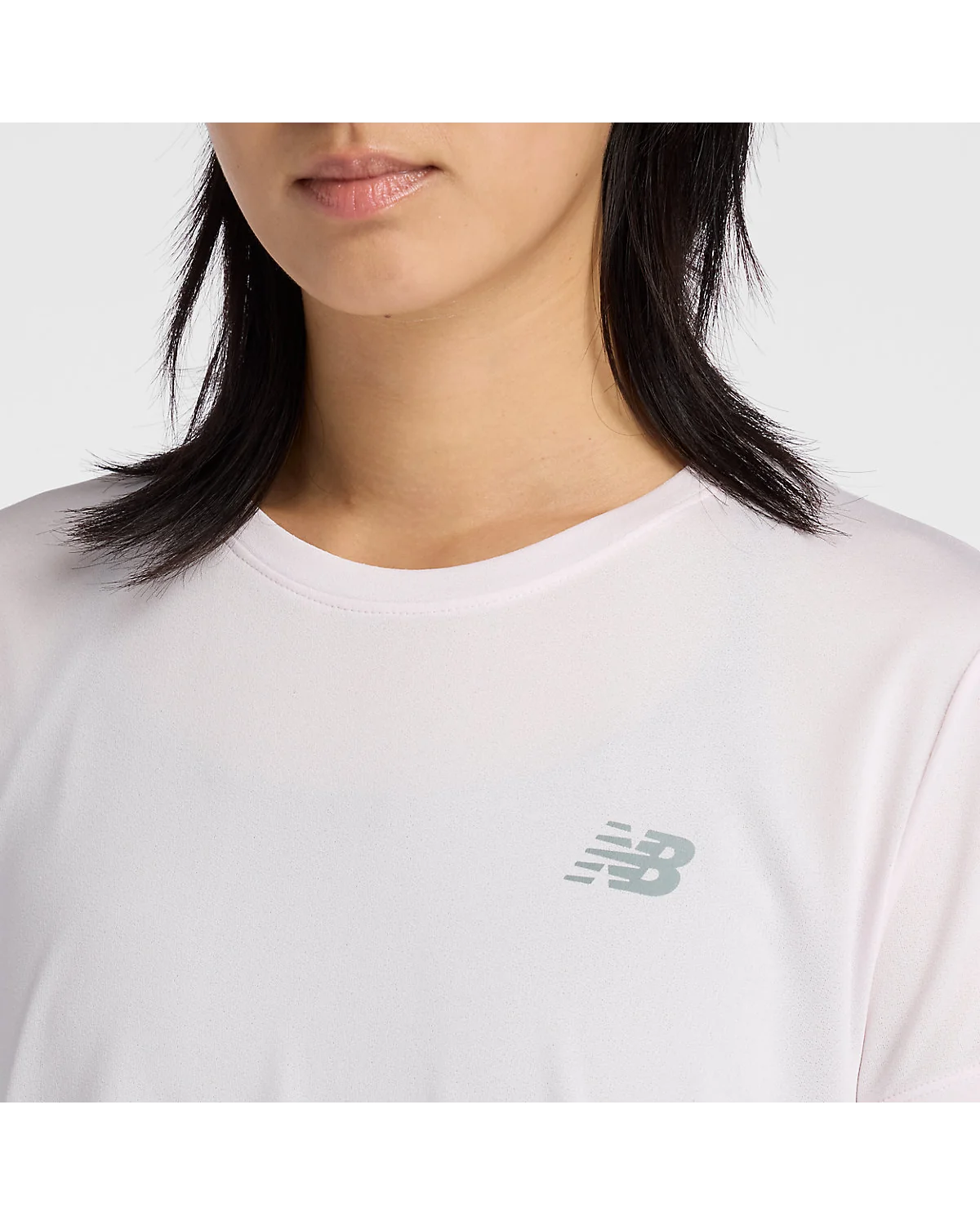 Вид сзади светло-розовой футболки New Balance на модели.