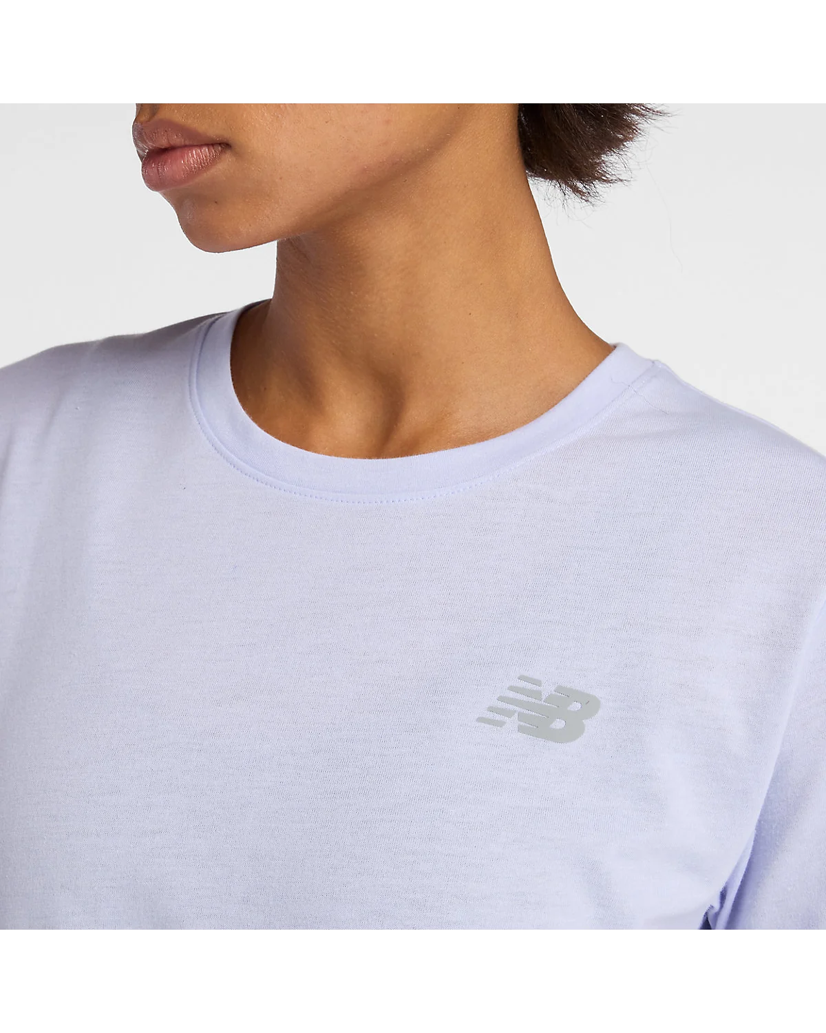 Крупный план ткани и логотипа голубой футболки New Balance.