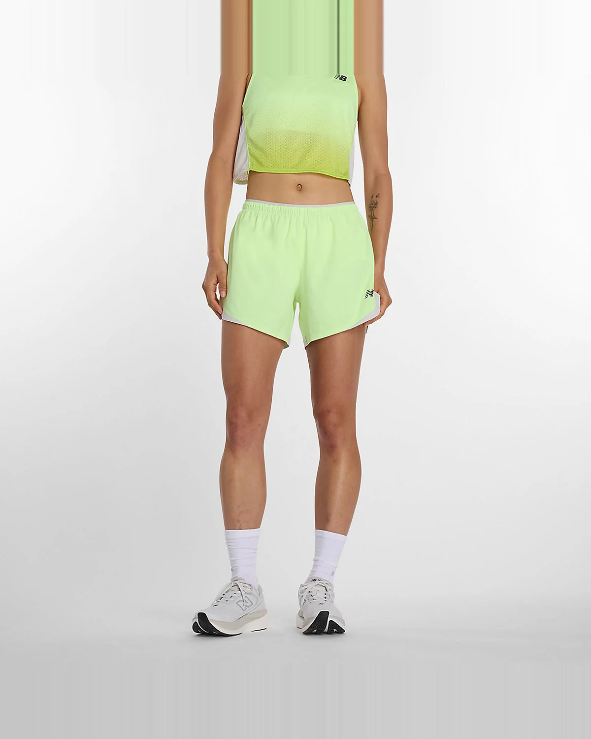 Салатовые с серым беговые шорты New Balance RC с карманами, вид спереди.