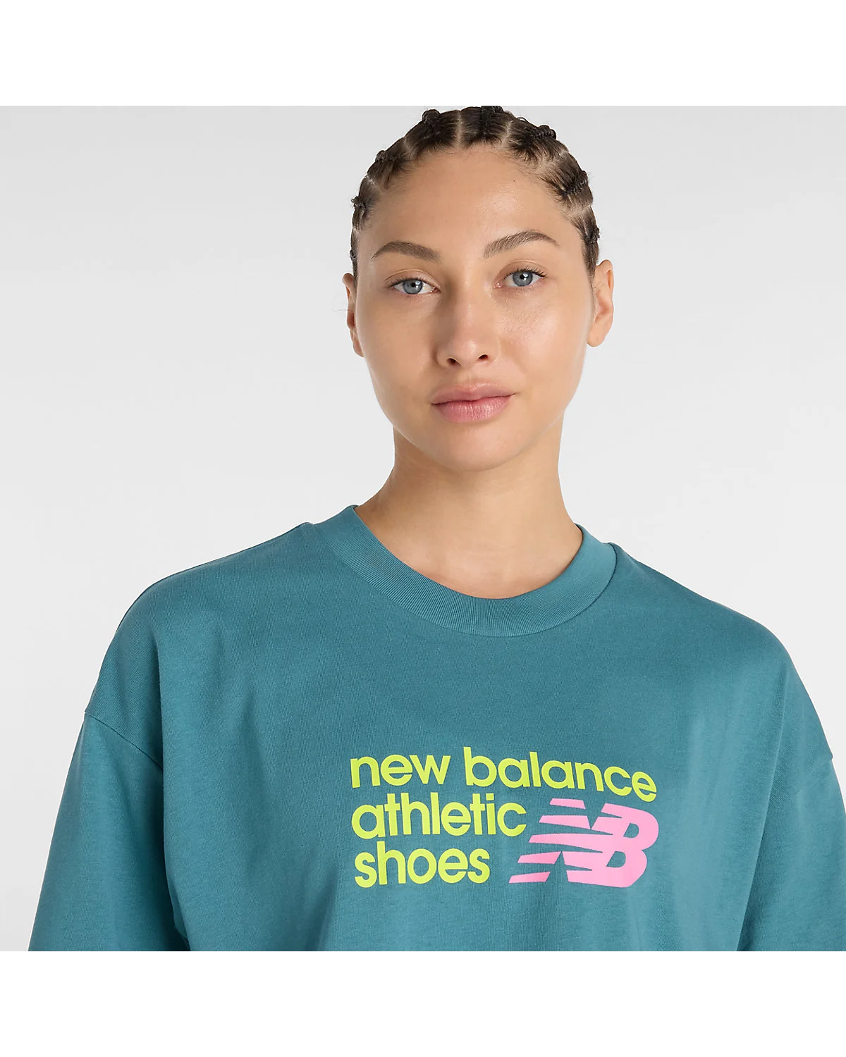 Модель в бирюзовой укороченной футболке New Balance, полный вид.