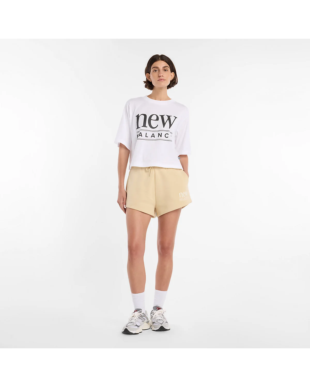 Бежевые флисовые шорты New Balance, полный вид на модели.