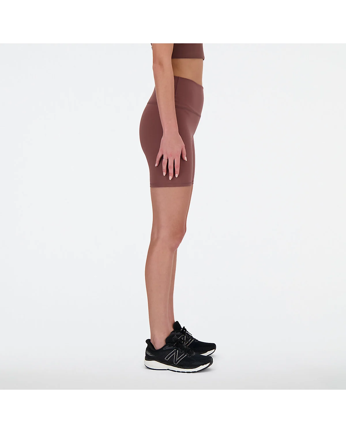 Крупный план пояса и деталей чёрных шортов New Balance с высокой талией.