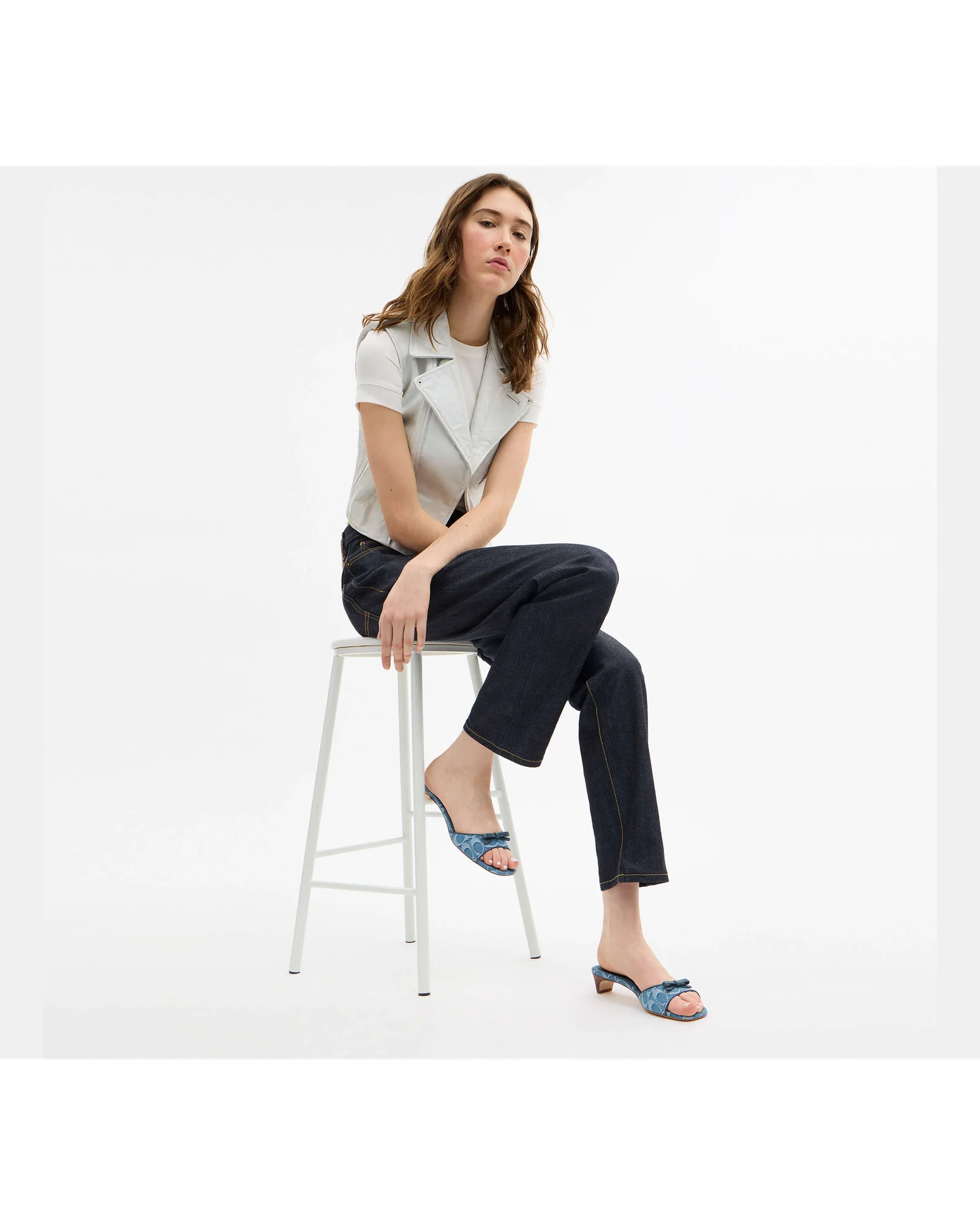 Сандалии Coach Bow Kitten Heel на моделе, вид сидя.