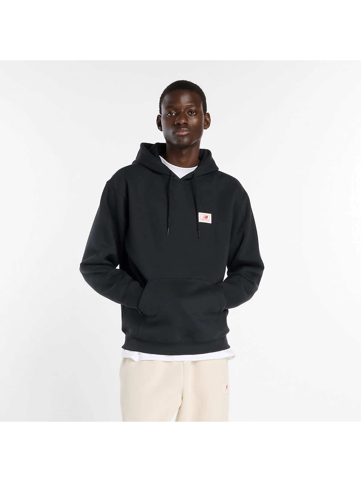 Чёрное худи New Balance с капюшоном и тканым лейблом, вид спереди