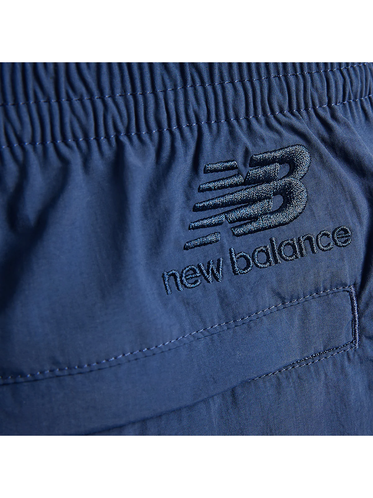 Крупный план талии серо-фиолетовых шорт New Balance со шнурком.