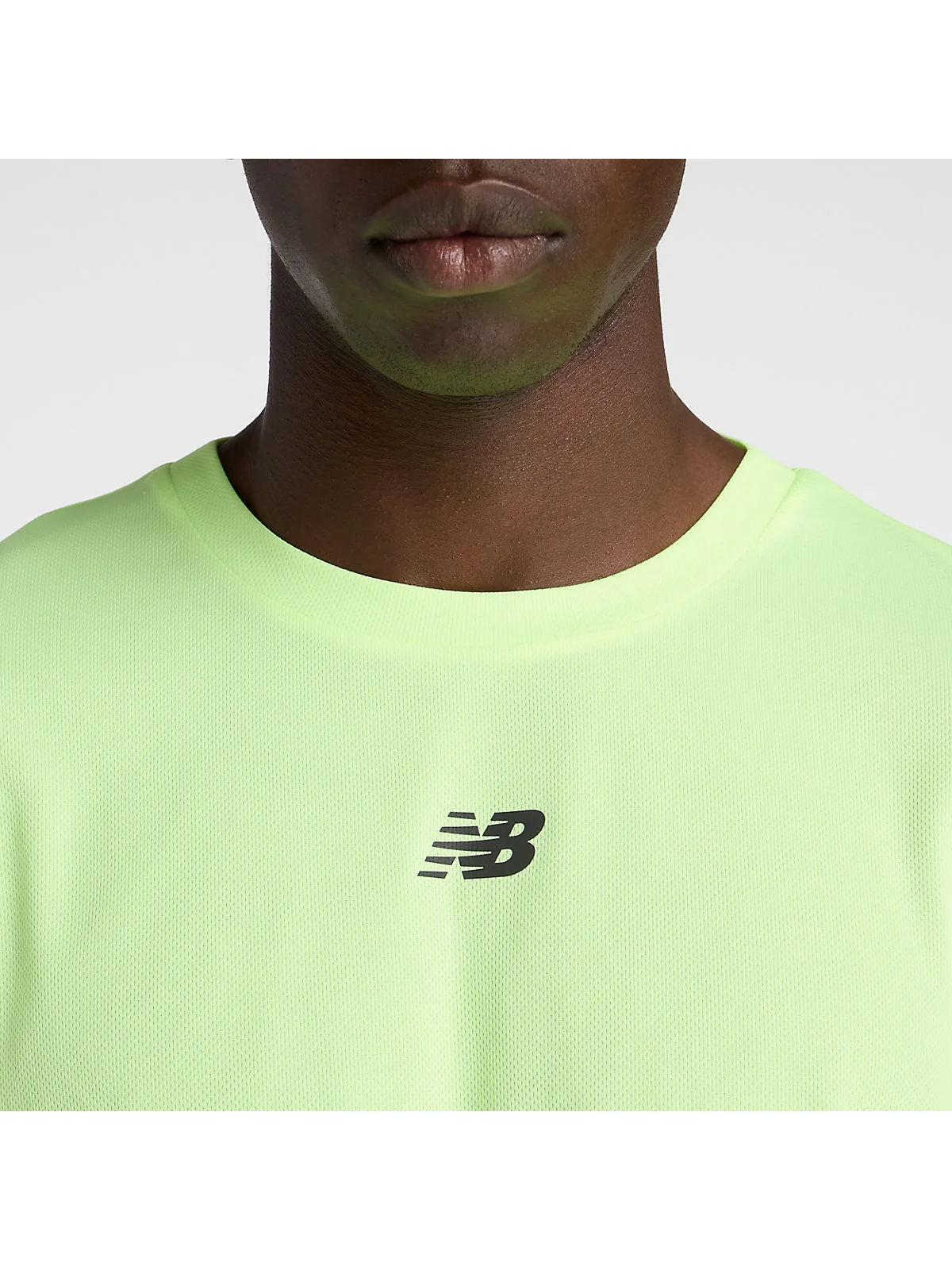 Крупный план логотипа и текстуры ткани беговой футболки New Balance, вид на грудь