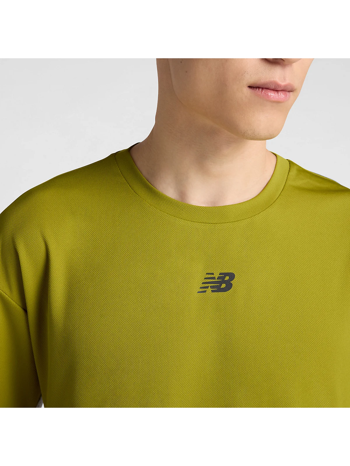 Крупный план логотипа и текстуры ткани беговой футболки New Balance на белом фоне