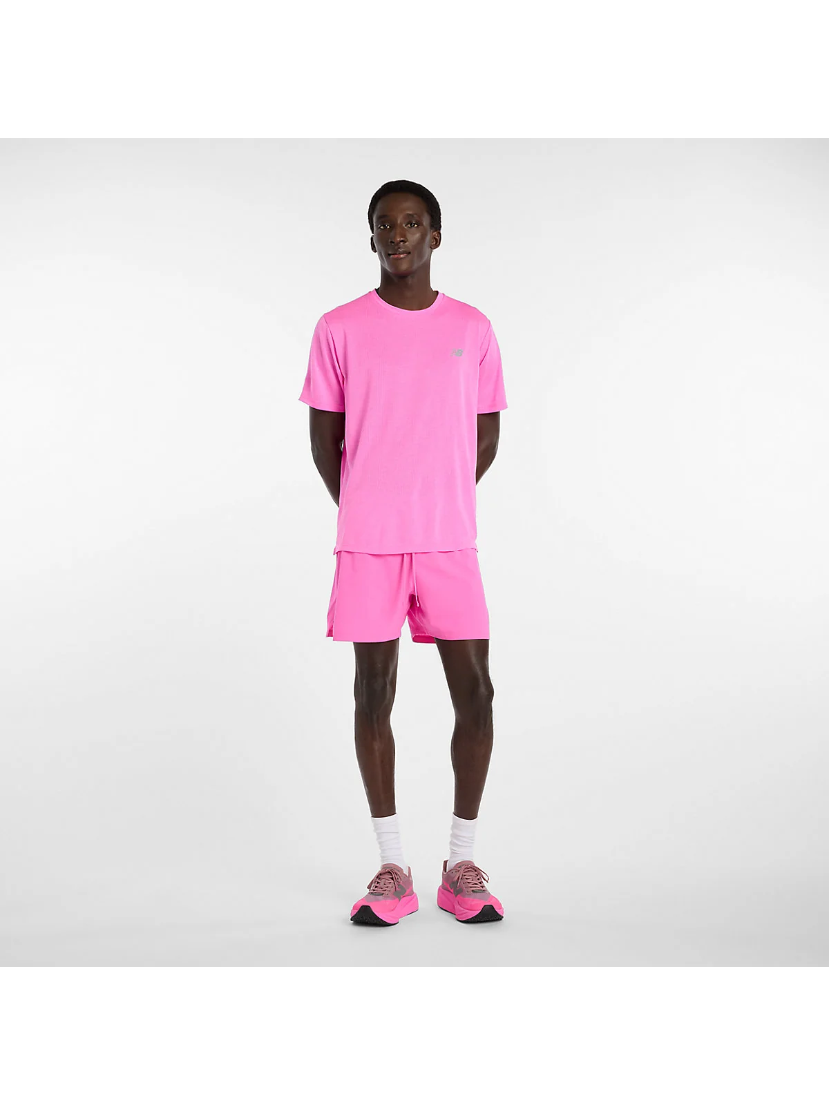 Розовые беговые шорты New Balance на модели в полный рост, вид спереди