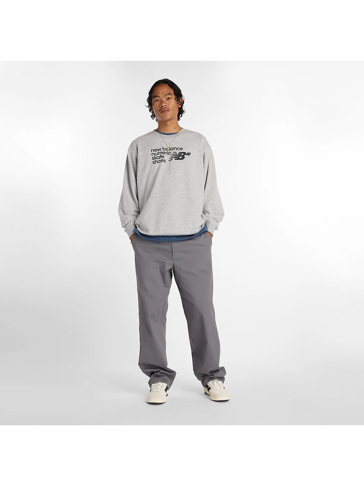 Серые брюки New Balance в полный рост, боковой вид.