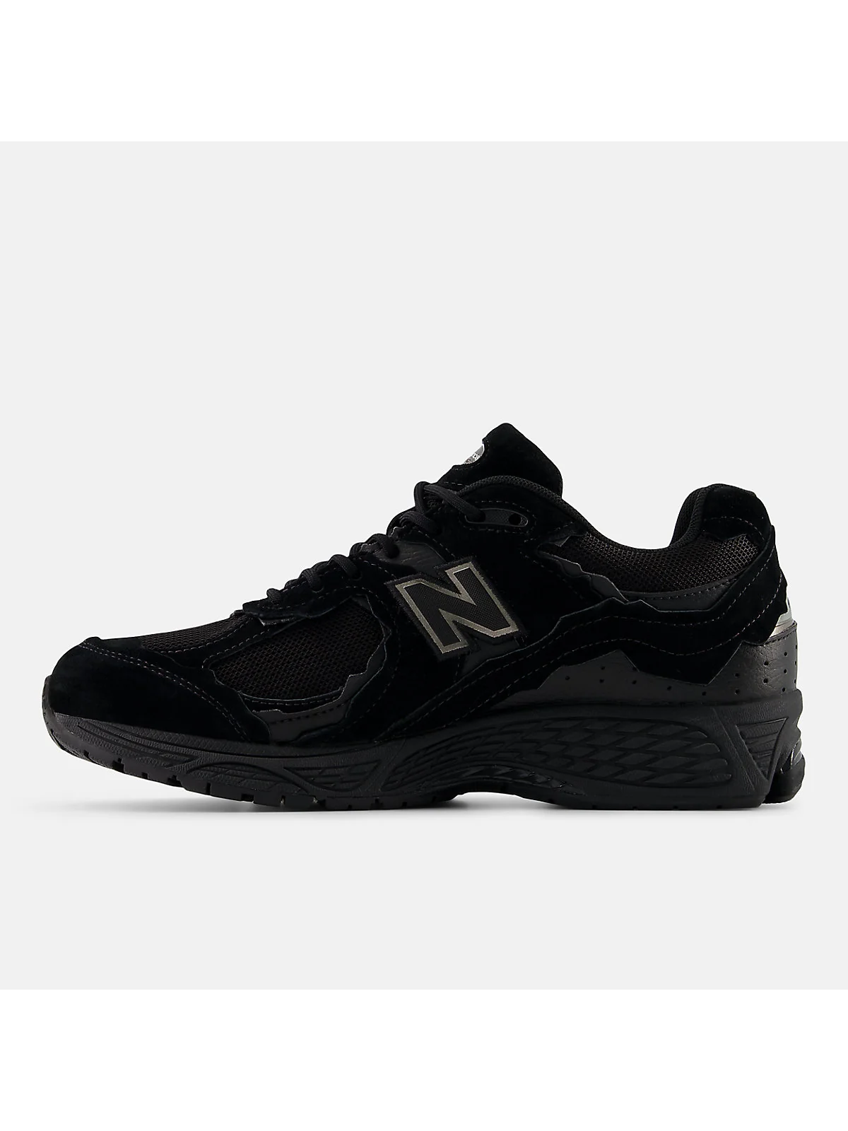 Чёрные кроссовки New Balance 2002DX сзади, видна пятка и структура подошвы.