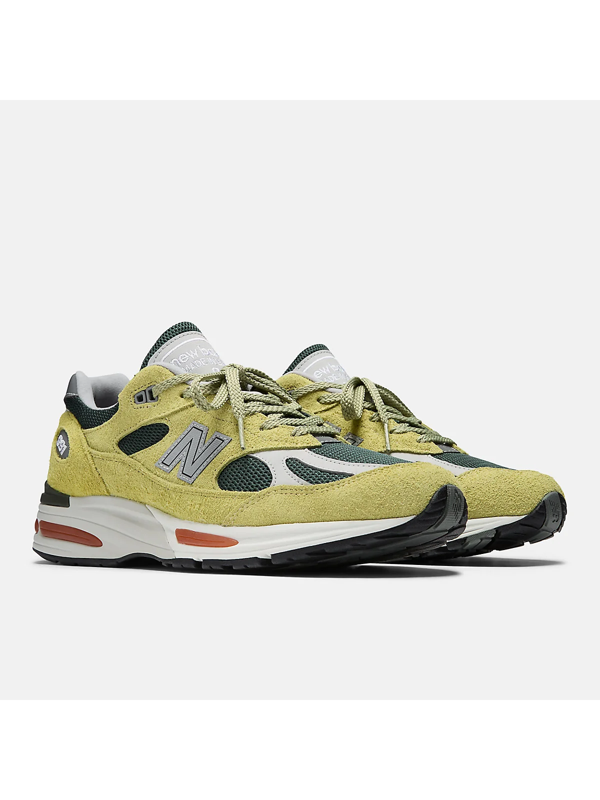 Бежево-зелёные кроссовки New Balance 991v2 с трекинг-зелёными панелями, разносторонний вид.