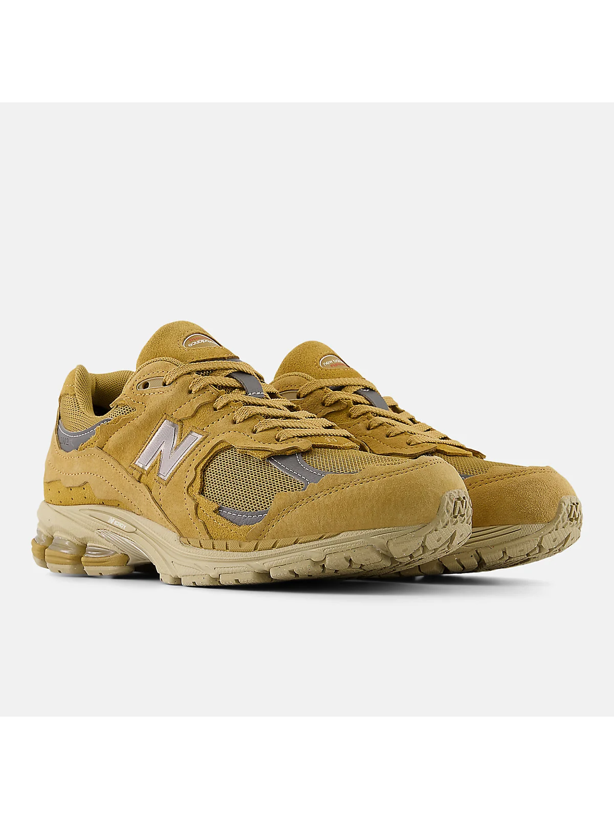 Бежевые кроссовки New Balance 2002DX, вид спереди-сбоку.