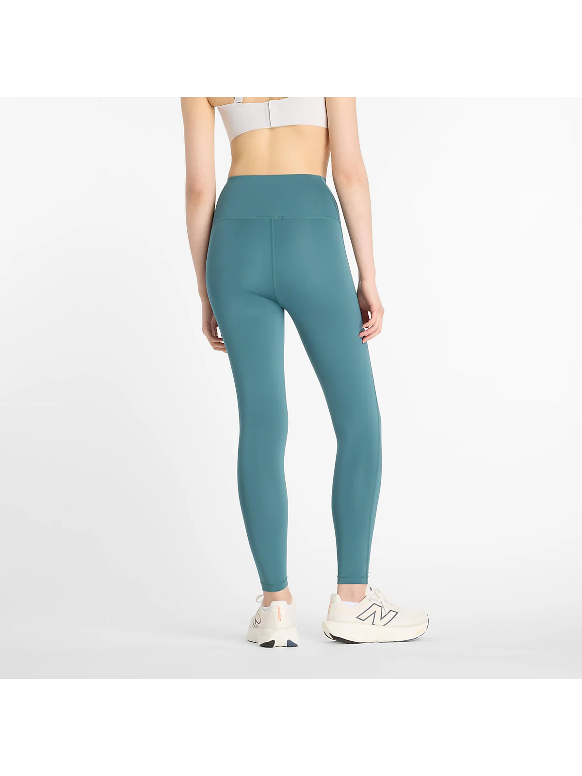 Вид сзади зелёных спортивных леггинсов New Balance Sport High Rise.