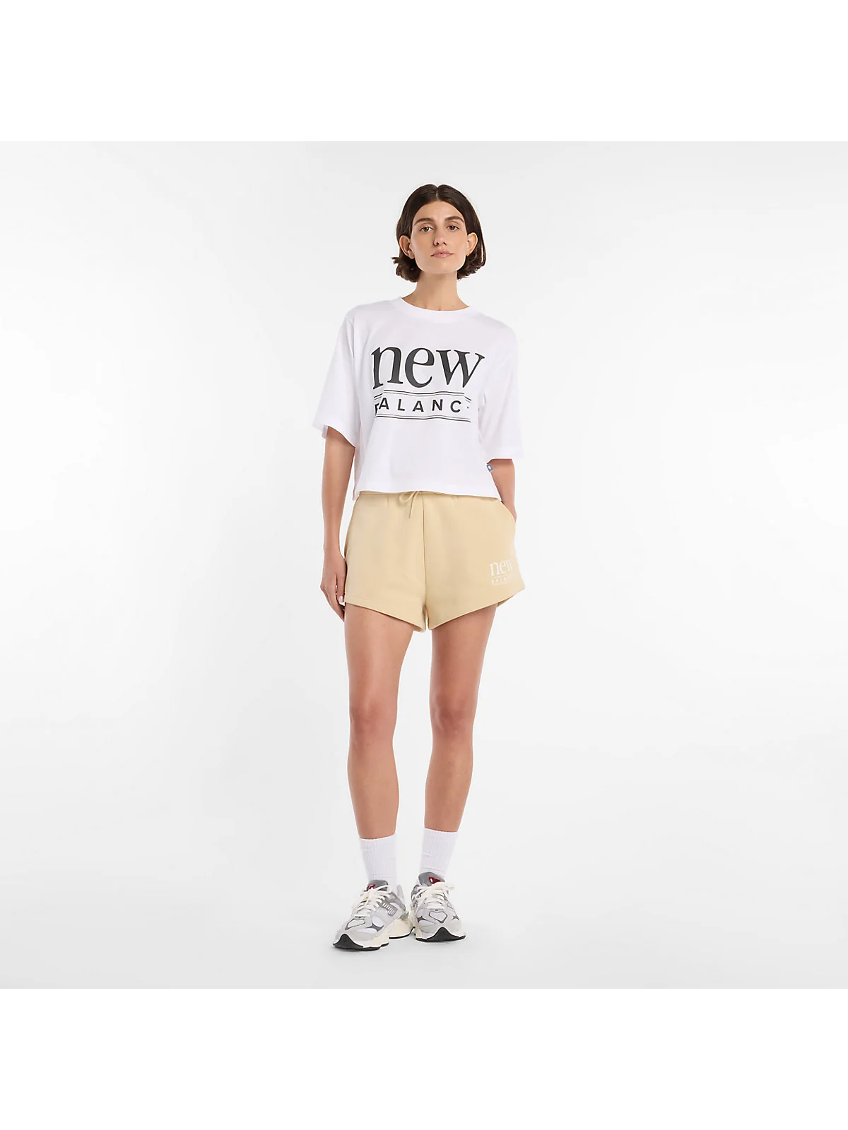 Бежевые флисовые шорты New Balance, полный вид на модели.